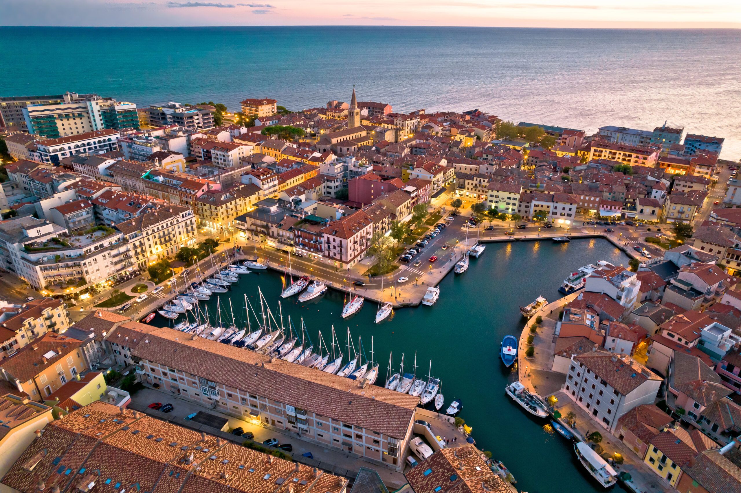 Città di Grado: architettura colorata e lungomare vista aerea serale